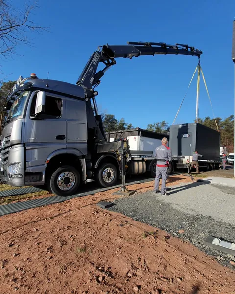 Kamion s dizalicom na pločama postavlja modularnu jedinicu